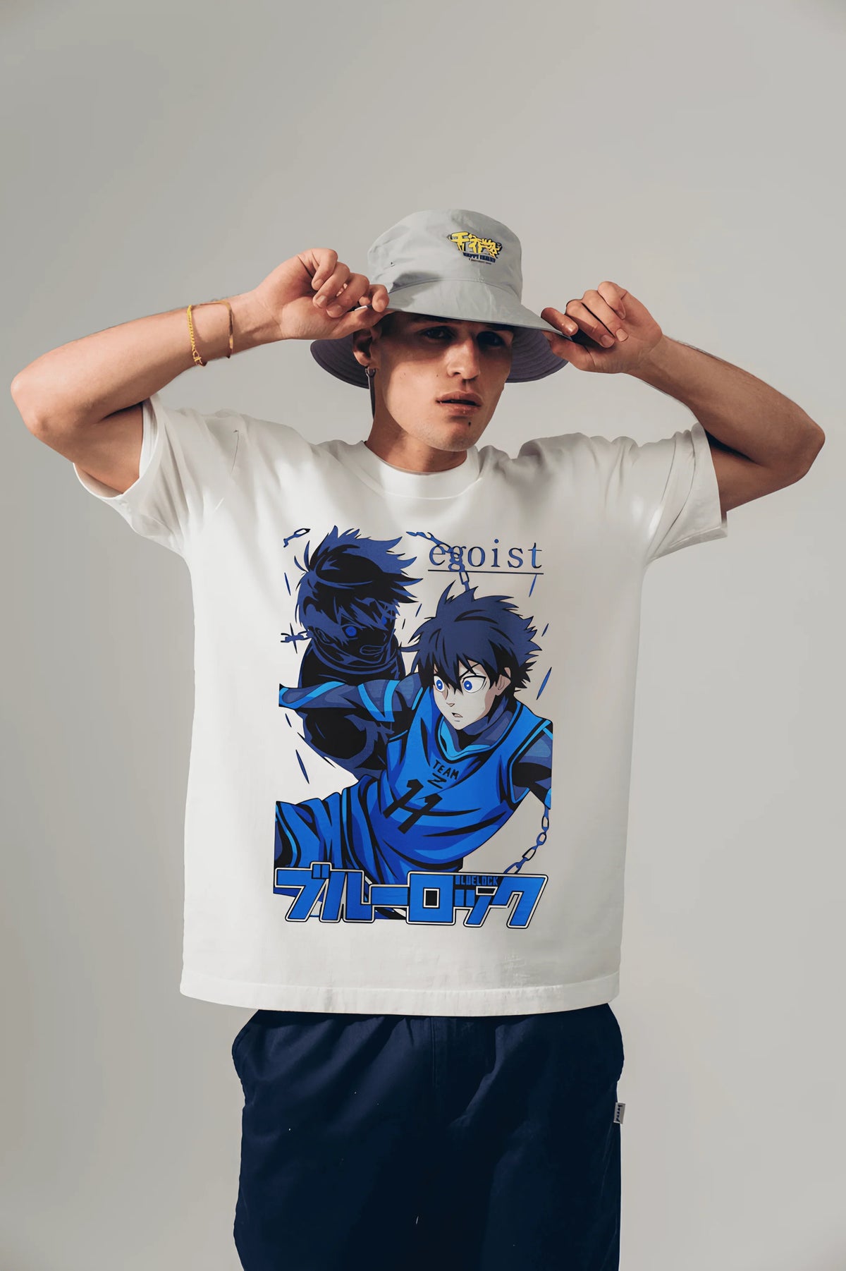 White Blue Lock anime T-shirt with egoist graphic, worn by model adjusting bucket hat