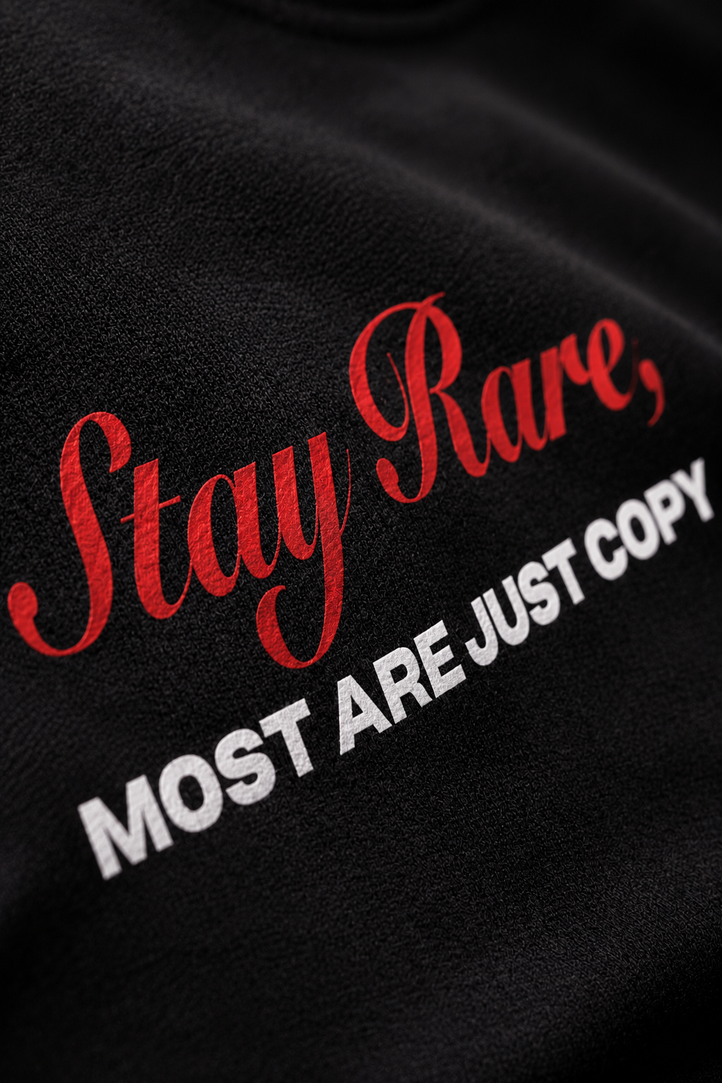 Genaura Stay Rare tee close-up, red script graphic detail on black